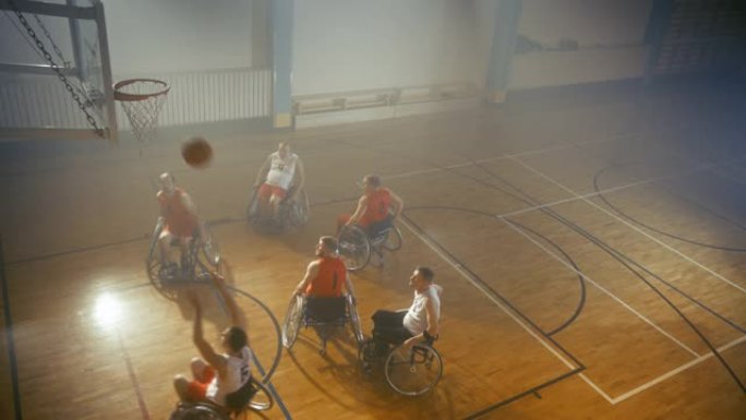 职业球场上的两队轮椅篮球比赛。截瘫球员比赛，射门，得分得分。残疾人的决心、技能。慢动作、高角度、航拍