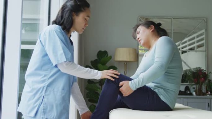 亚洲女性理疗师治疗手术中膝盖疼痛的女性患者