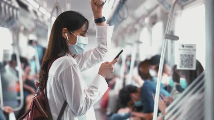 在地铁列车上使用智能手机的女人