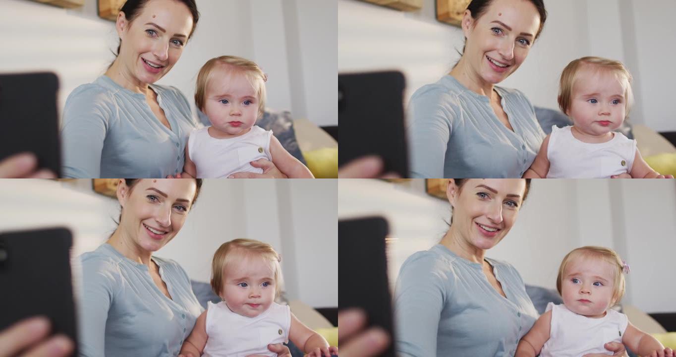 高加索母亲在家中与婴儿在智能手机上自拍