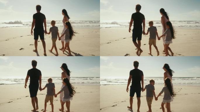 轻松，快乐或充满爱心的家庭在海滩上散步，结伴并享受海洋假期或暑假。母亲、父亲和孩子们一起玩乐，手牵手