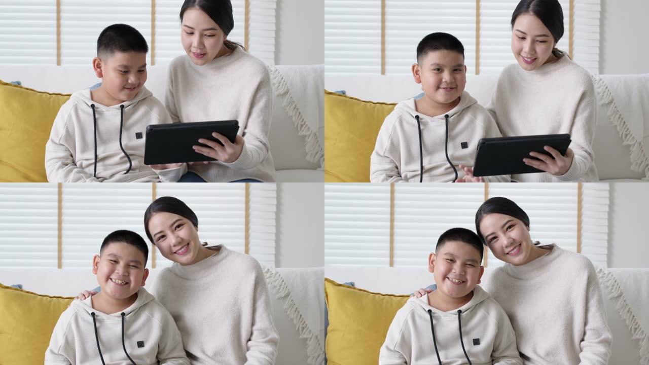 肖像亚洲家庭妈妈和儿子孩子在家平板电脑在线学习。