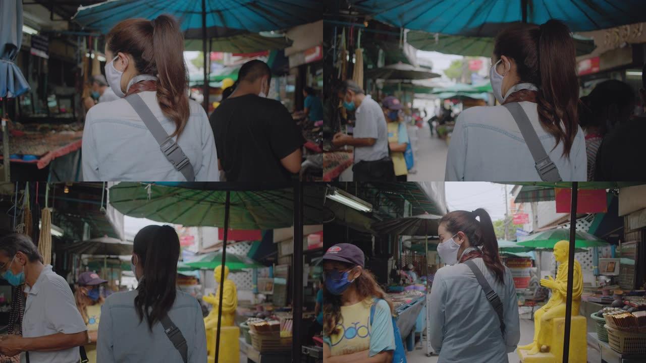 亚洲成年妇女在当地旅游场所散步和购物。迷人的女性在当地旅行时寻找街头美食。单人旅行者概念。