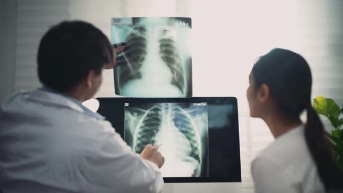 持有x射线摄影胶片的亚洲医生向患者解释结果