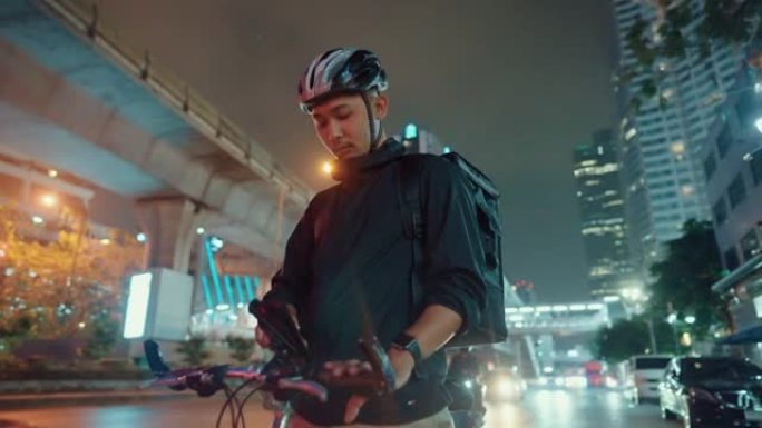 自行车送货员在穿越城市夜晚。