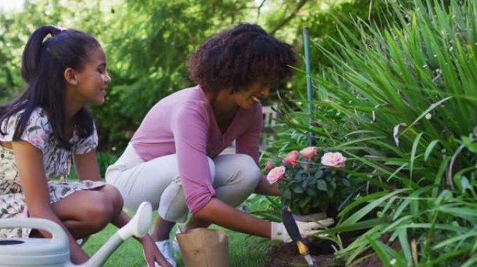 快乐的非洲裔美国母女，照顾户外植物