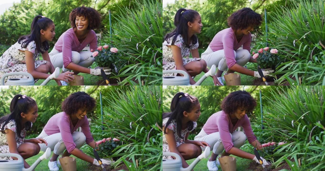 快乐的非洲裔美国母女，照顾户外植物