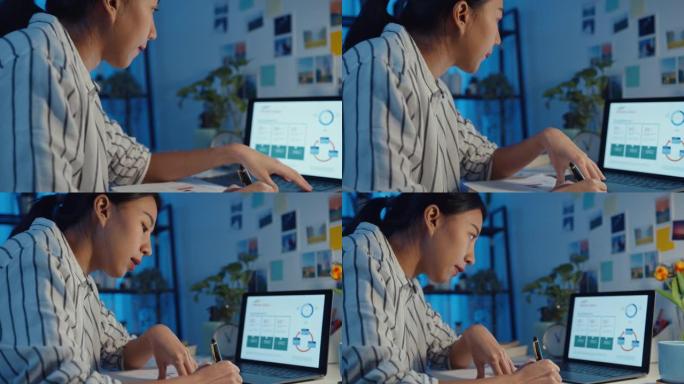 年轻的亚洲商务女士自由职业者专注于笔记本电脑写工作表财务图表账户图表市场计划在笔记本电脑和平板电脑在