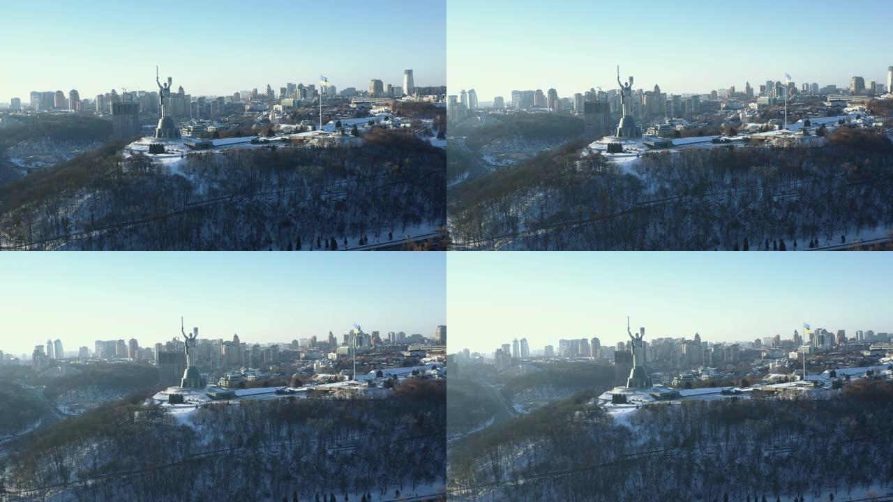 壮丽的乌克兰国旗和史诗般的祖国雕像纪念碑的空中全景在基辅在雪天晴朗的冬天。