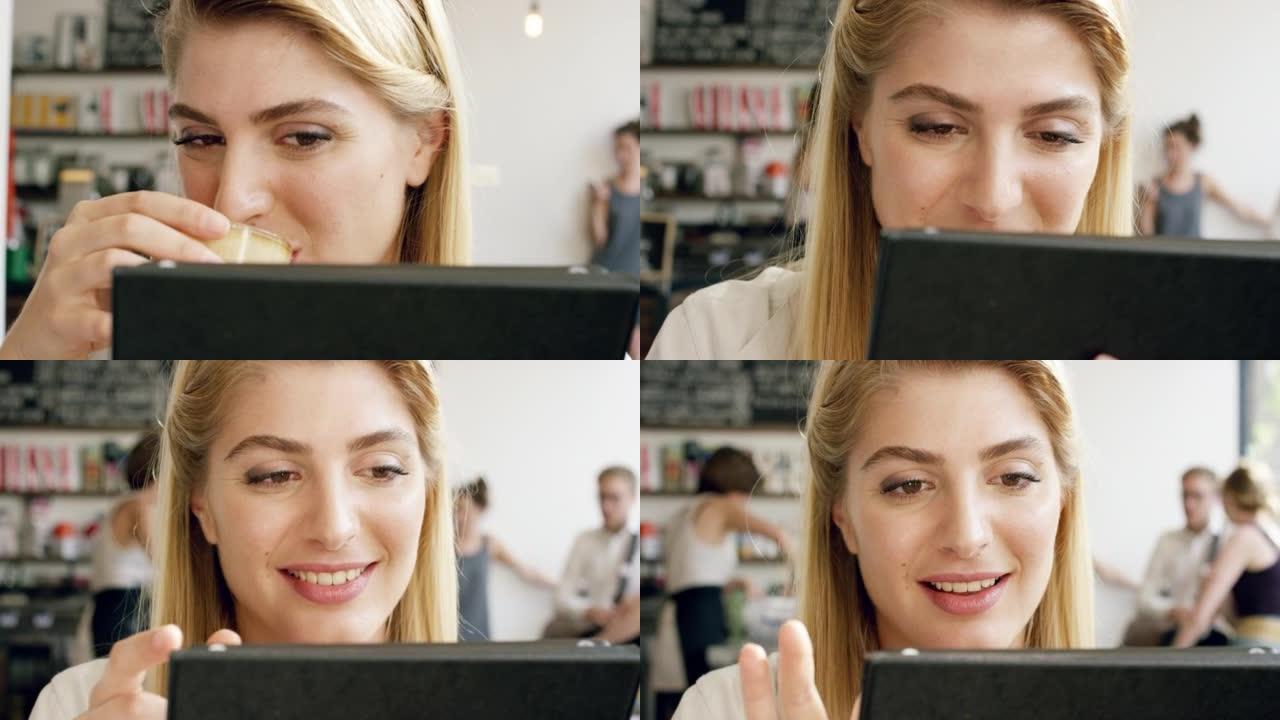 4k视频片段，一个迷人的年轻女子独自坐在咖啡馆里，使用数字平板电脑