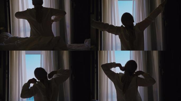 女人醒来，早上坐在酒店房间的床上，伸出双臂，看着窗外