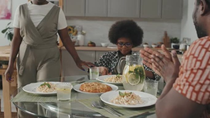 非裔美国人三口之家在吃饭前祈祷