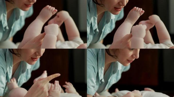 妈妈在和她的宝宝玩耍，宝宝抓着她的食指。它代表了母亲对婴儿的爱与纽带。