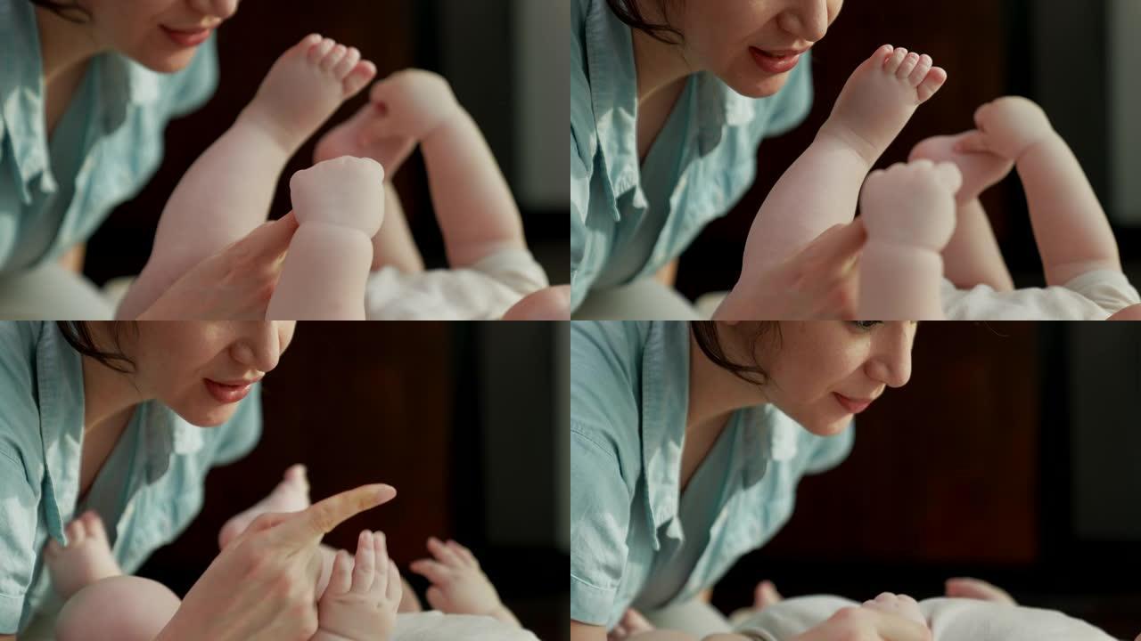 妈妈在和她的宝宝玩耍，宝宝抓着她的食指。它代表了母亲对婴儿的爱与纽带。