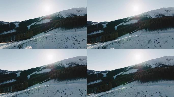 在冬季阳光明媚的早晨，雄伟的空中风景是森林岩石和大雪覆盖的山脊，带有滑雪缆车。