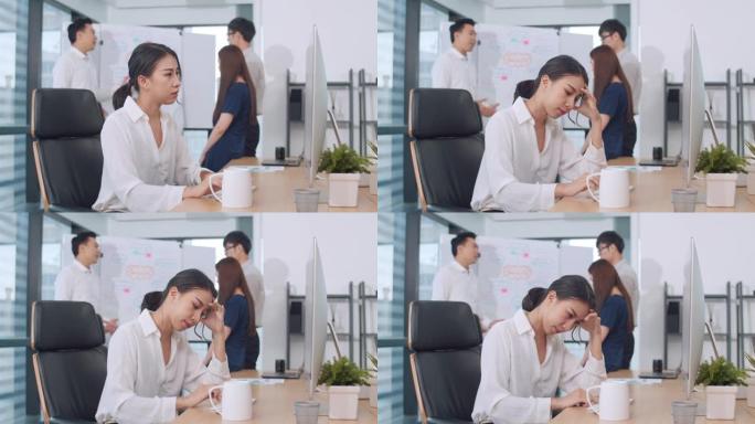 女商人在小型现代办公室会议室的计算机桌面上解决项目研究问题。亚洲人职业倦怠综合症的概念。