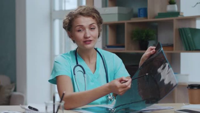 医生女人在网上诊所的笔记本电脑上与病人视频通话。女医师在视频会议上咨询远程人员。聪明的护士晚上在室内
