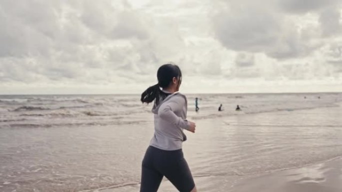 在海滩上跑步的运动女人