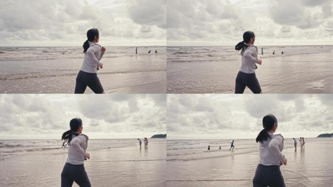 在海滩上跑步的运动女人