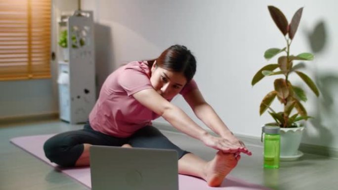 在笔记本电脑上观看瑜伽在线课程并独自在家练习
