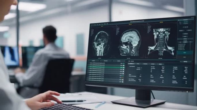 医学医院研究实验室: 白人女性神经外科医生使用计算机与脑部扫描MRI图像，为患病患者寻找最佳治疗方法