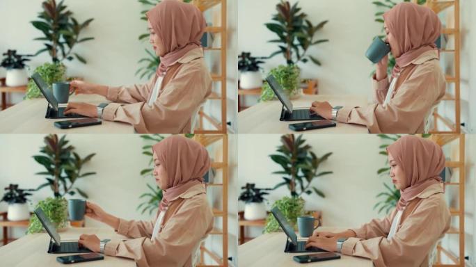 亚洲穆斯林妇女坐在家里舒适地工作。