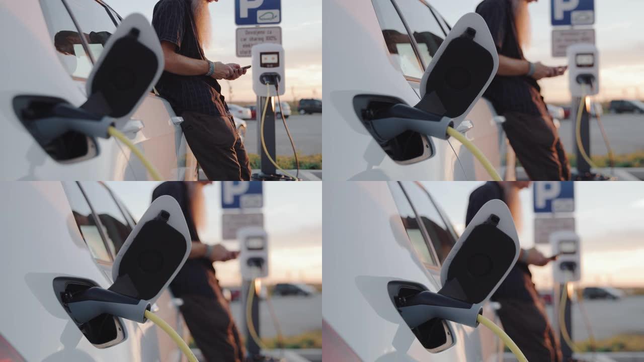 SLO MO Hipster在等待汽车充电时使用智能手机