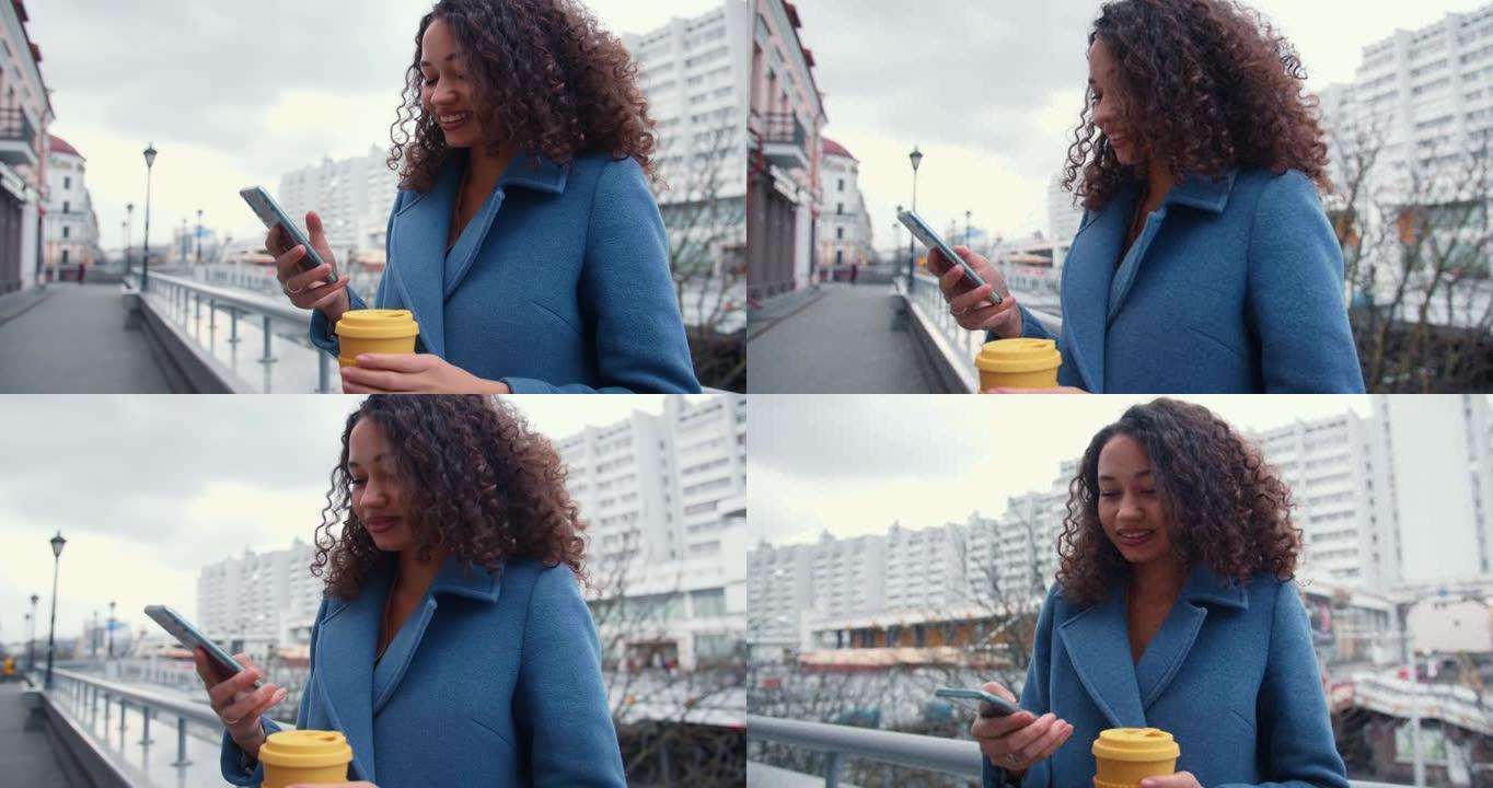 电子商务概念。美丽的年轻快乐成功的混血商业女人在城市街道上使用智能手机微笑。