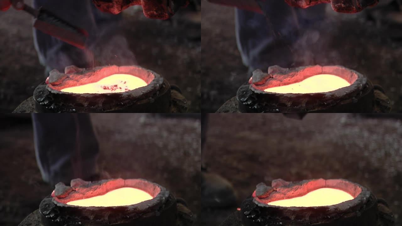 工人在铸造厂用液态金属将金属片放入模具中。特写。