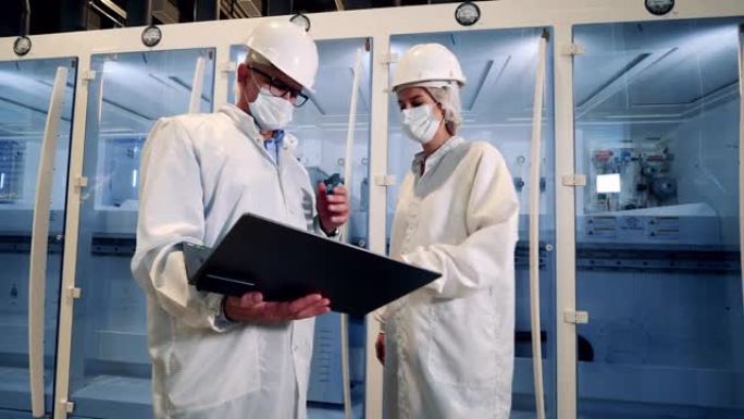 两位穿着实验室外套的工程师正在讨论现代技术