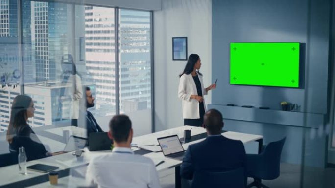 多元化的办公室会议室会议: 成功的亚洲女商人演讲，使用绿屏色度键墙电视向投资者群体展示产品。电子商务
