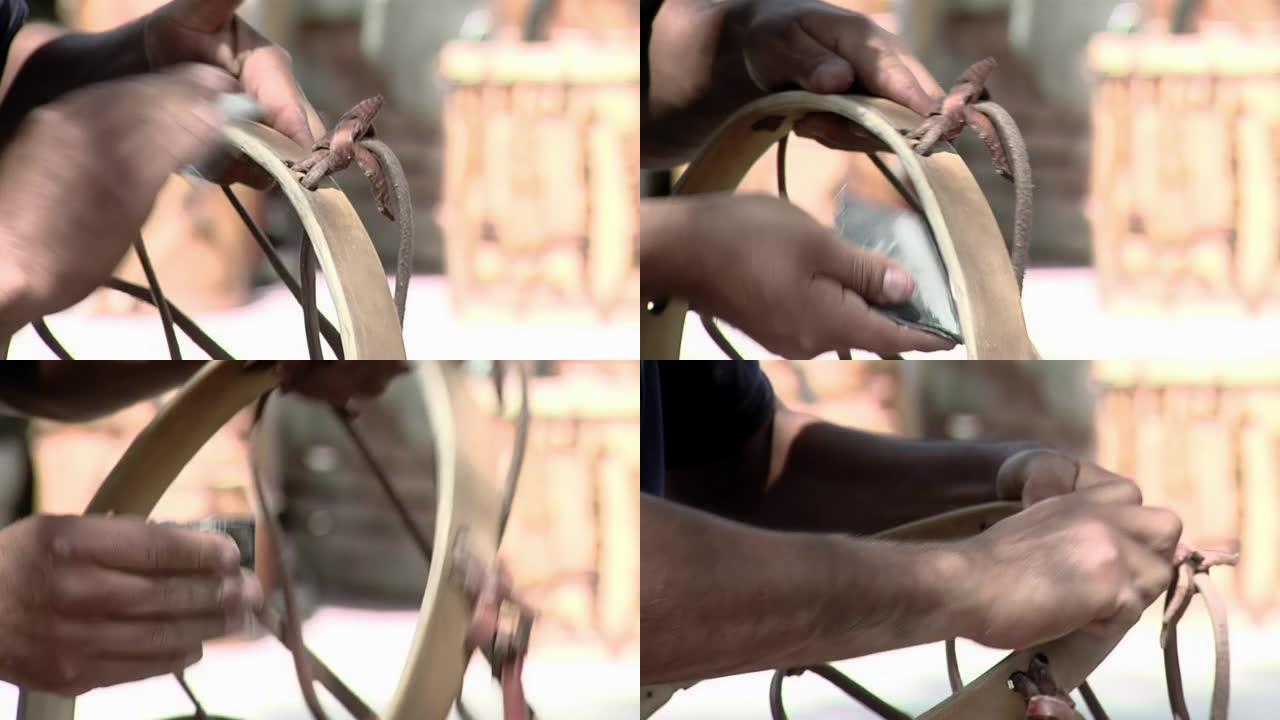 一名男子正在修复一个典型的“Bombo Legüero”，这是一种由木头和动物皮革制成的阿根廷民间鼓