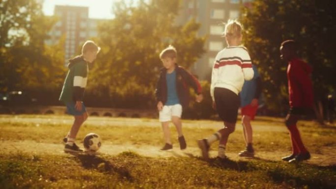 夏天阳光明媚的日子，才华横溢的多民族多样的孩子在后院踢足球。喜欢足球、童年和友谊的运动男孩和女孩。
