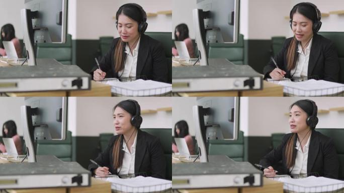 在公开办公室工作的亚洲中国中年女性在网上与客户交谈时写下信息