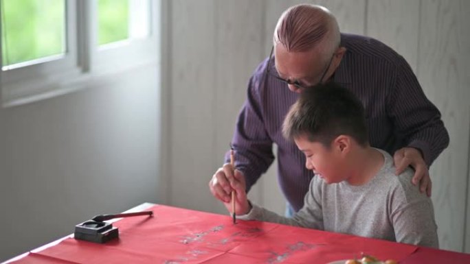 亚洲华裔小男孩向祖父学习中国书法