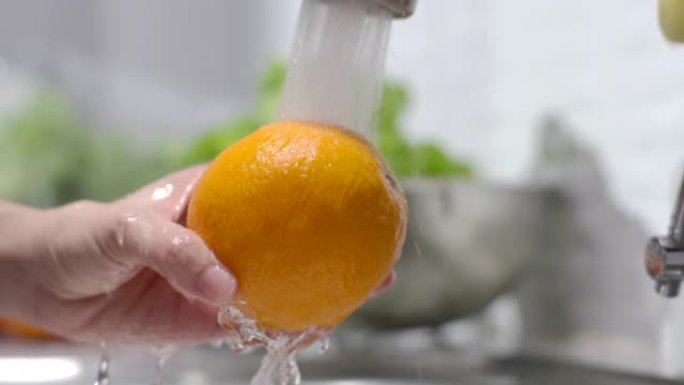 手洗橙色水果，慢动作