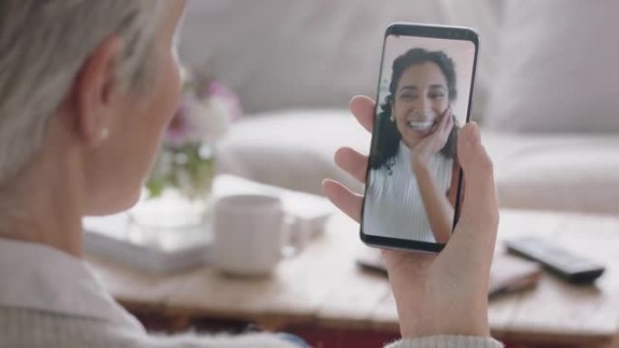 成熟的女人使用智能手机与朋友聊天在手机屏幕上微笑享受对话分享生活方式4k