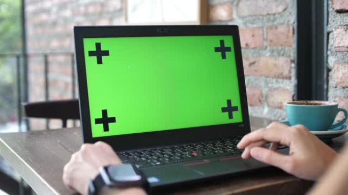 女人使用带绿屏的笔记本电脑