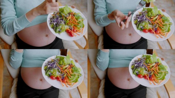 迷人的孕妇在家吃沙拉的特写