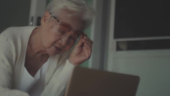 亚洲老年女性使用笔记本电脑，老花眼