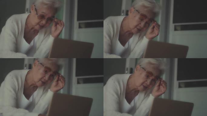 亚洲老年女性使用笔记本电脑，老花眼