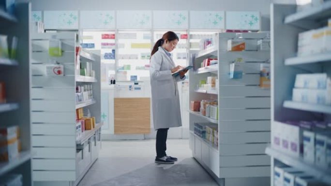 药店药店: 美丽的中国药师使用数字平板电脑，检查库存的药品，药品，维生素，保健品在一个货架上。制药商