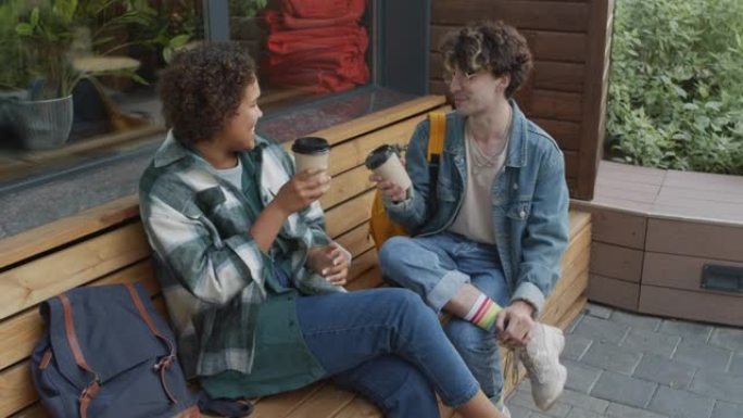 朋友在咖啡馆的长凳上喝咖啡