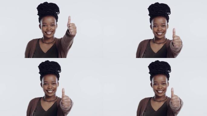 4k录像片段，一名年轻女子站在摄影棚的白色背景下竖起大拇指