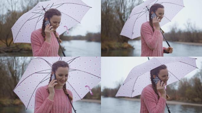 十几岁的女孩在雨天撑着伞，打电话