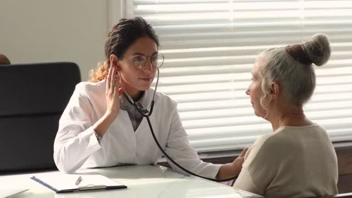 医师使用听诊器聆听老年患者的心脏声音
