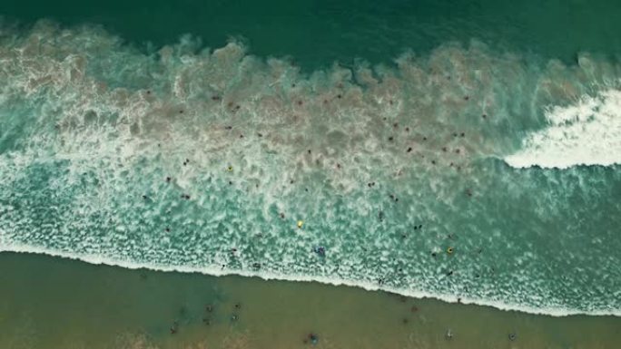 享受海浪的人们面对大海海潮涨退潮