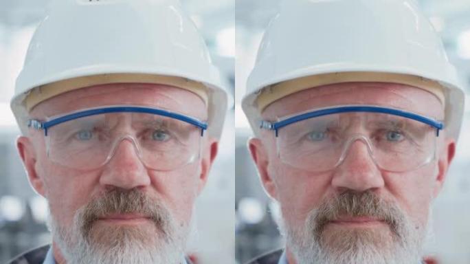 垂直屏幕: 一位戴着安全帽和安全眼镜的资深成功男性工程师的特写肖像，站在电子制造工厂。重工业专业人士