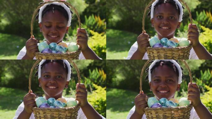 微笑的非洲裔美国女孩戴着复活节兔子耳朵，在花园里拿着一篮子复活节彩蛋