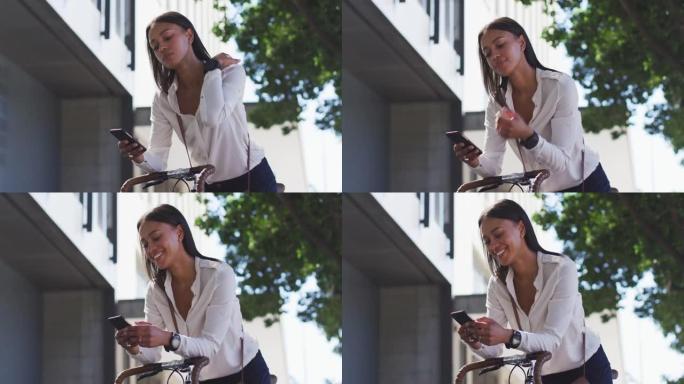 非裔美国妇女在街上使用智能手机倚靠自行车